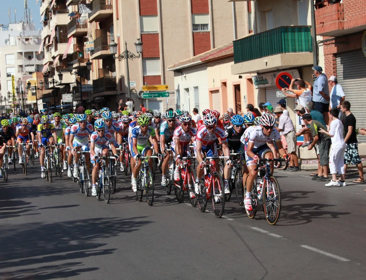 a group of cyclists on street next to buildings