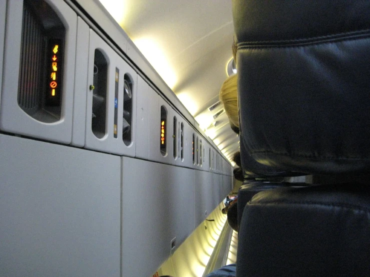 a person is sitting on an airplane and is looking towards the left