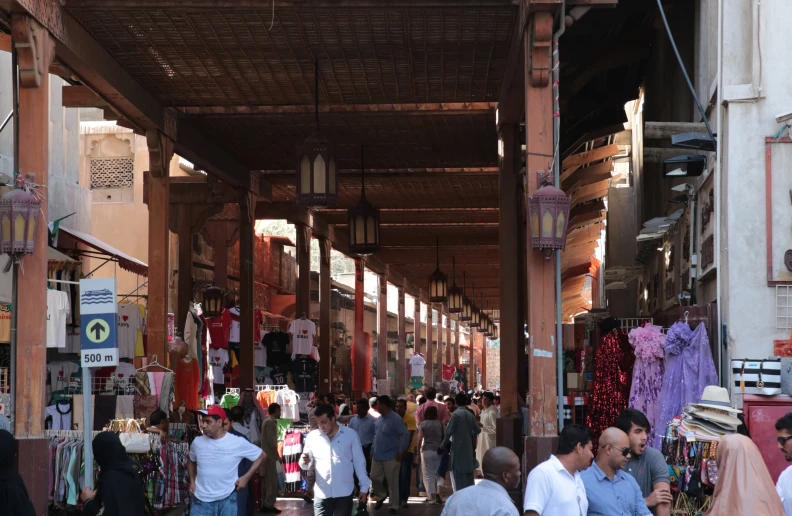 many people walking through an outdoor market in india