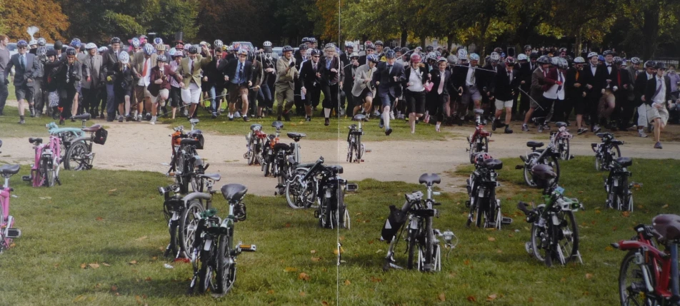 a large crowd of people looking at motorcycles and riders in various poses