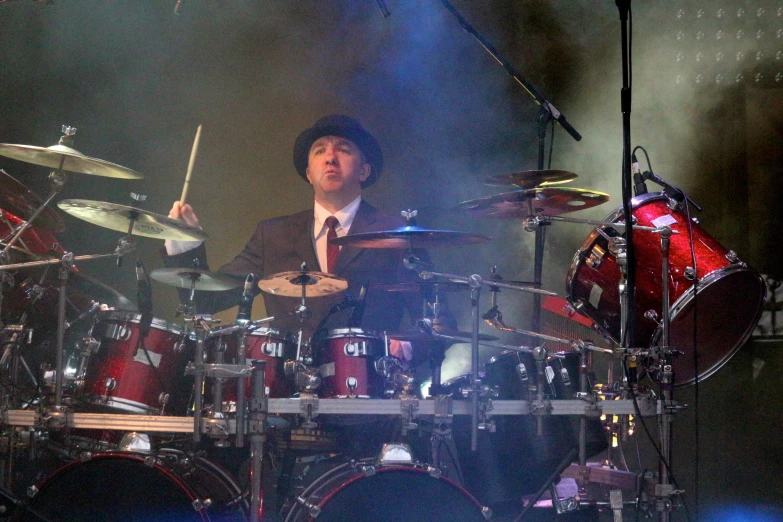 a drummer is playing drums while a band plays on the drums