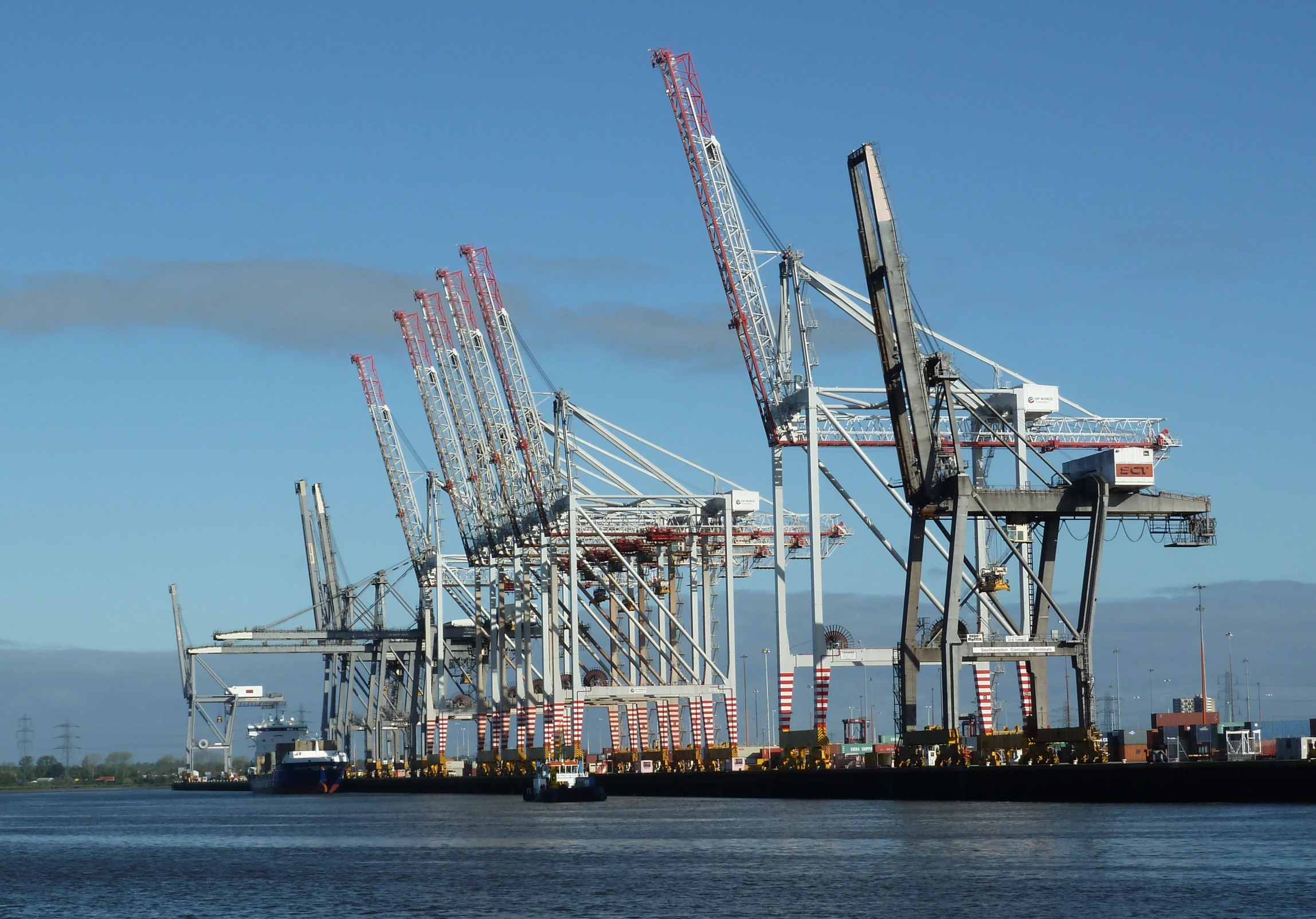 several cranes sit atop of a barge near the ocean