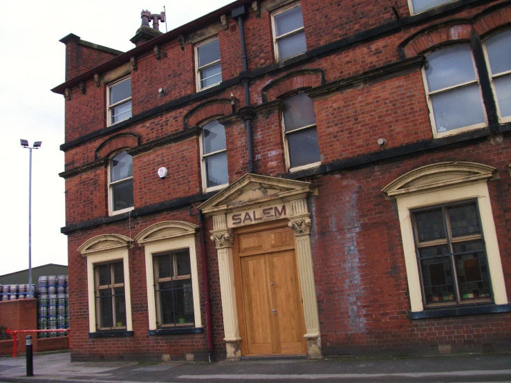 a brick building with boarded up windows and arched top doors