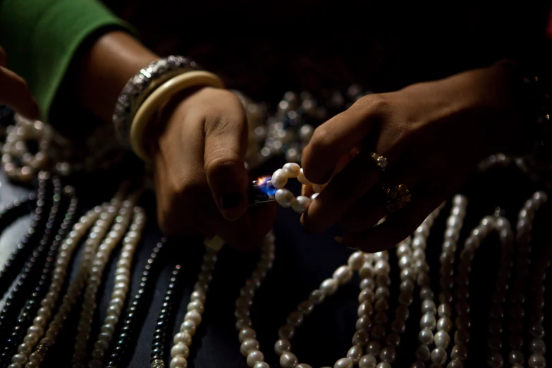 a woman holds pearls and necklaces with her hands