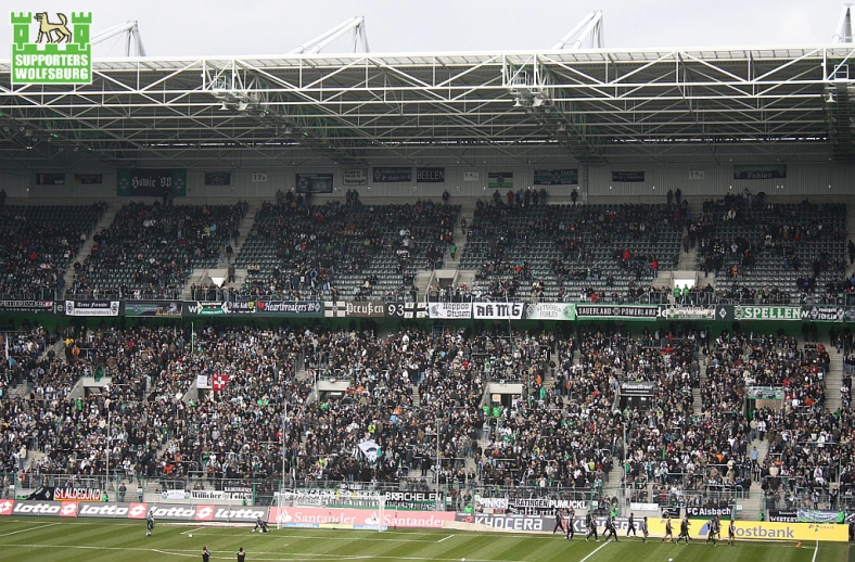 a crowded stadium with a soccer field and rows of spectators