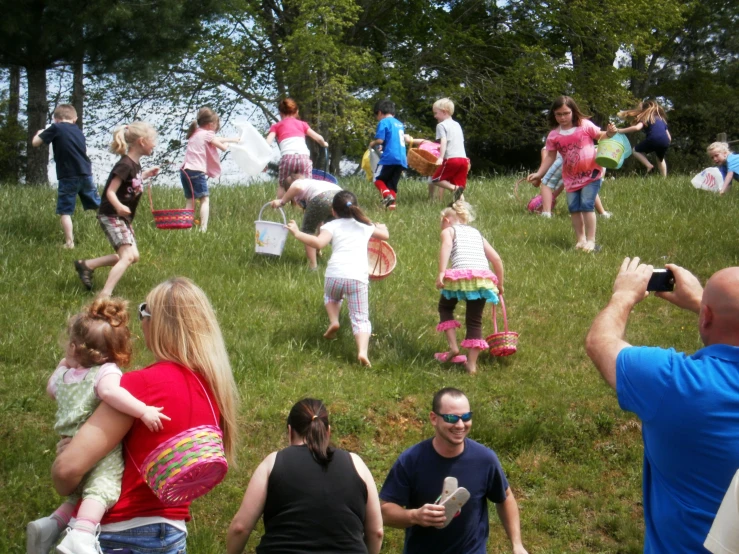 a lot of children and adults walking on the grass