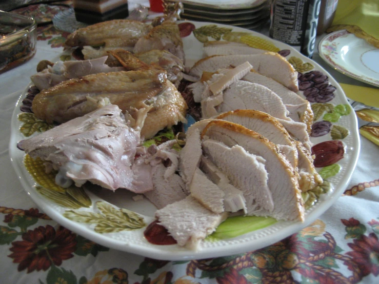 a large plate with sliced turkey and other foods