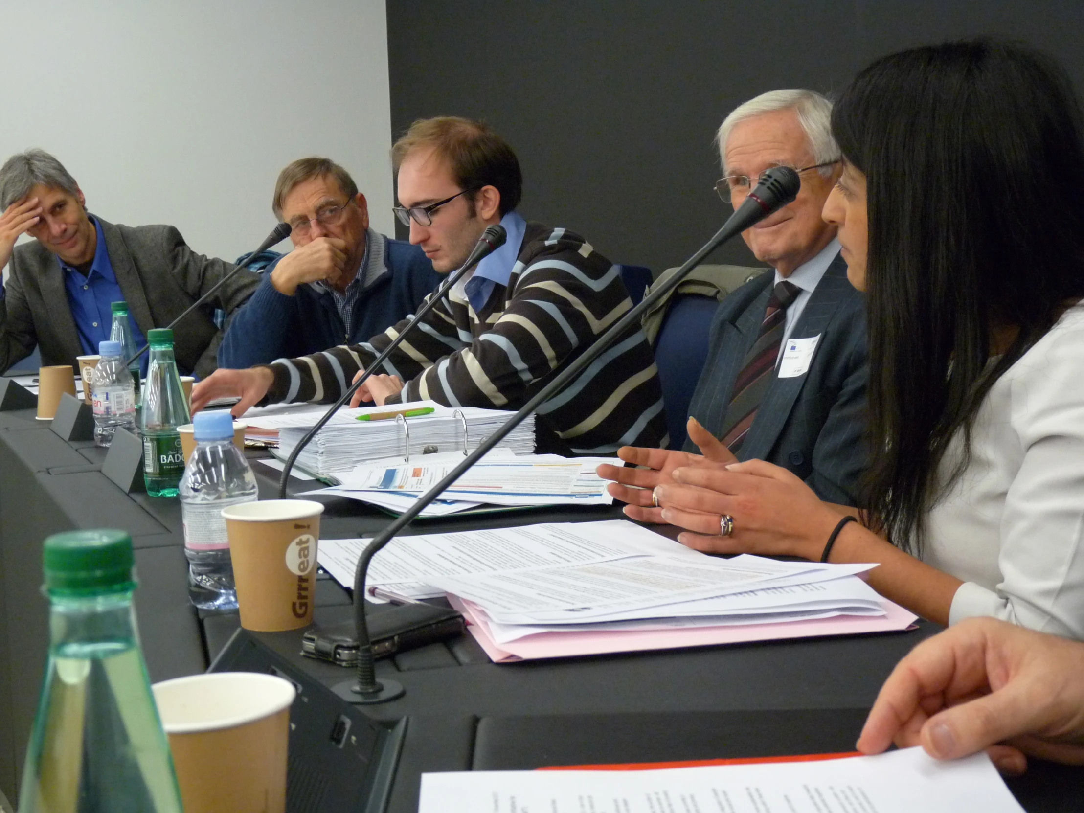 four people are sitting at a table during a meeting