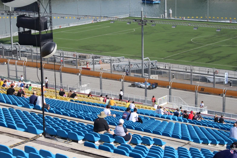 blue stadium seats, some empty and one person in a green uniform