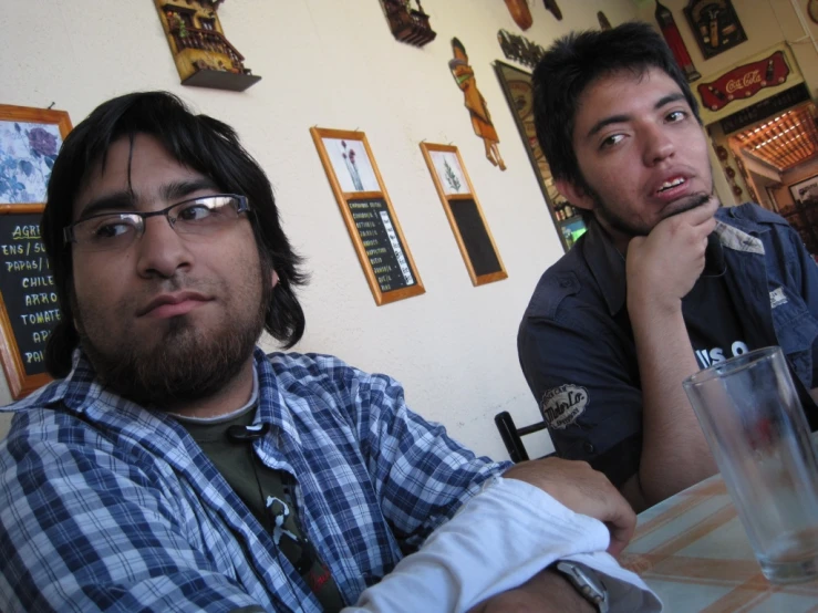 two young men sitting at a table talking