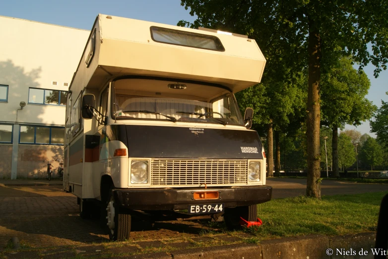 a camper van sits outside in a city park