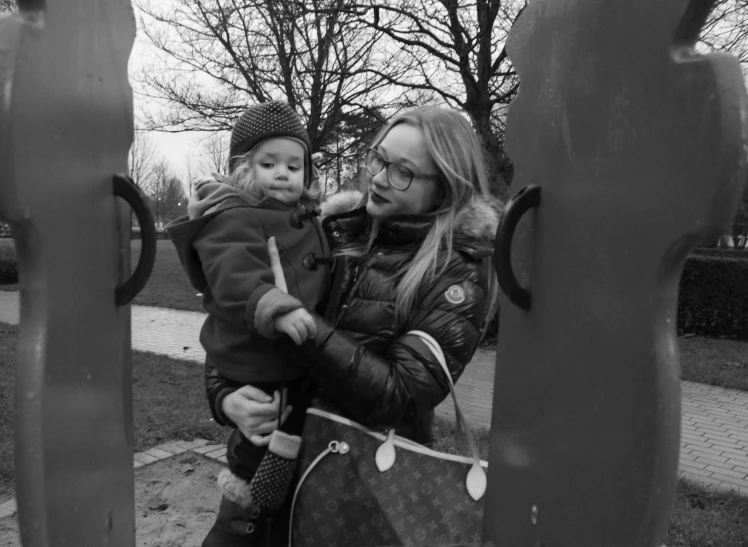 the mother and baby look through metal rings