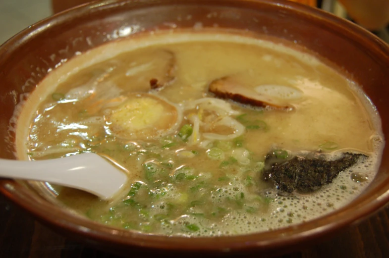 a bowl filled with soup and topped with meat