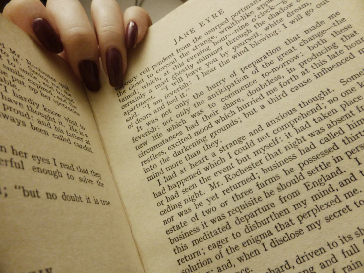 a woman holding a book with her right hand