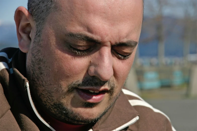 man using cellphone outdoors in the street, close - up