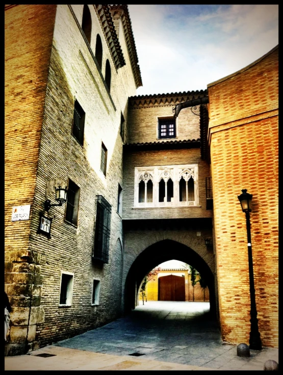 an old brick building with arched doorways between two buildings