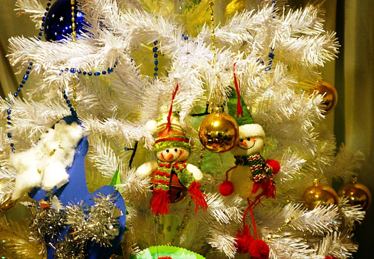 a white tree is decorated with bright ornaments