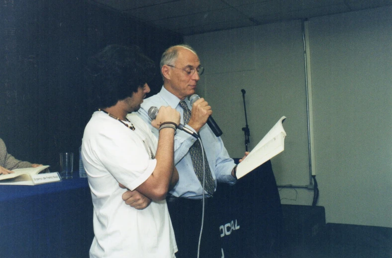 two people standing behind a microphone and microphone