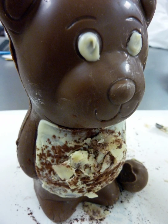 a brown teddy bear statue sitting on top of a white counter