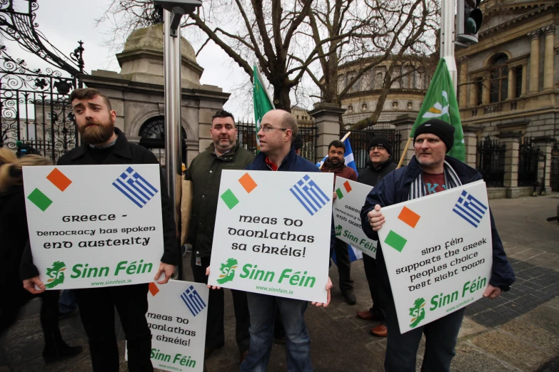 a group of people holding up signs in the street