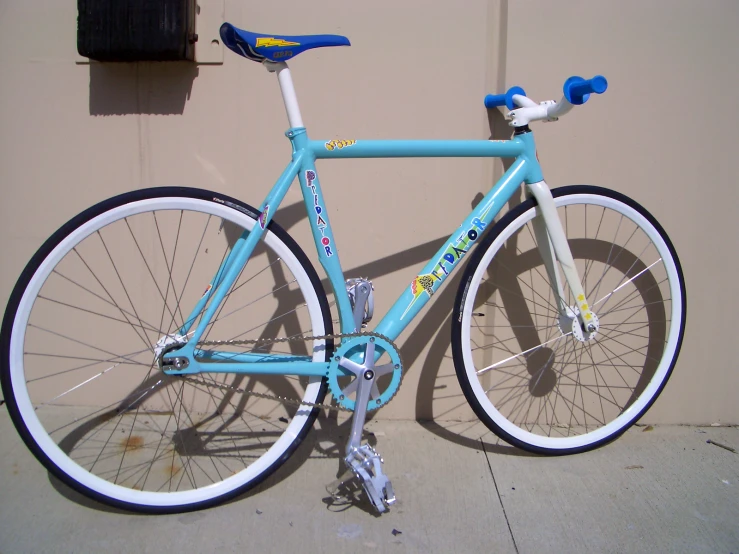 a bike is standing on the sidewalk next to a wall