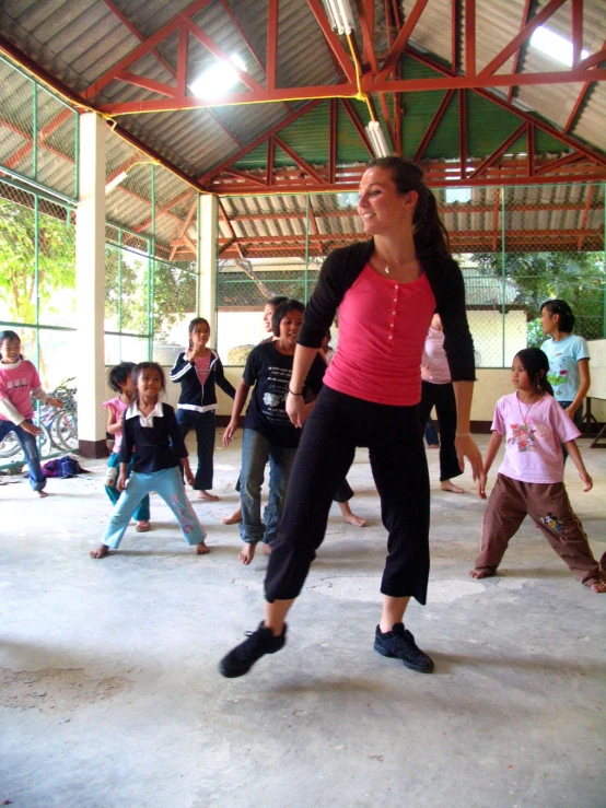 woman in a gym with a line of children