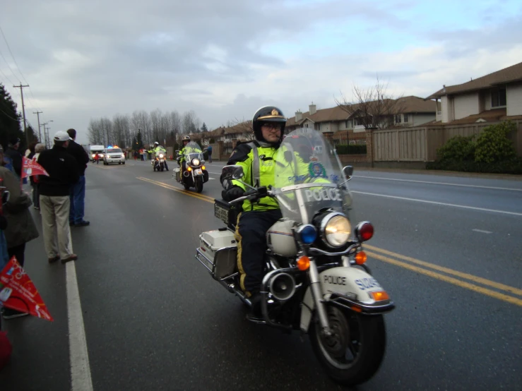 a policeman riding a motorcycle with police officers behind him