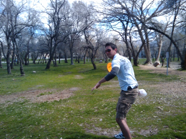 man in glasses playing with a yellow frisbee
