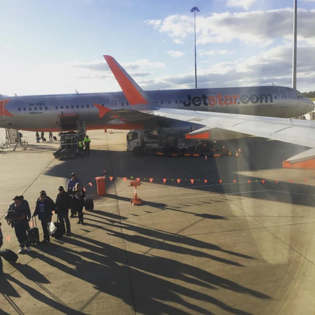 some people and a passenger jet at an airport