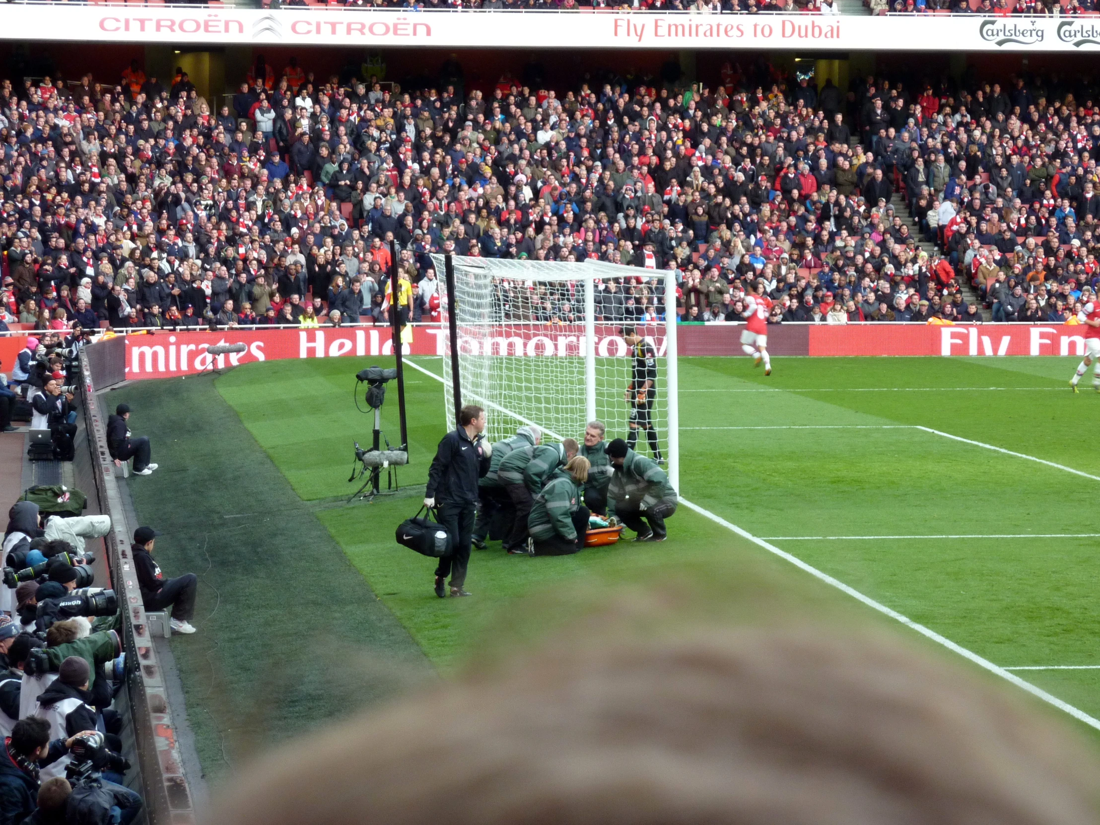 a crowd watches as a group of soccer players play