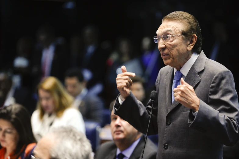 a man standing at a microphone while speaking