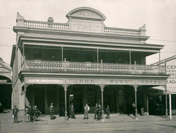 several men standing outside a building with wrought iron railing