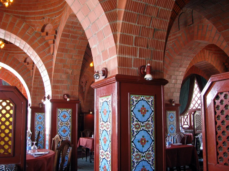 a dining area with several columns, tables and lights