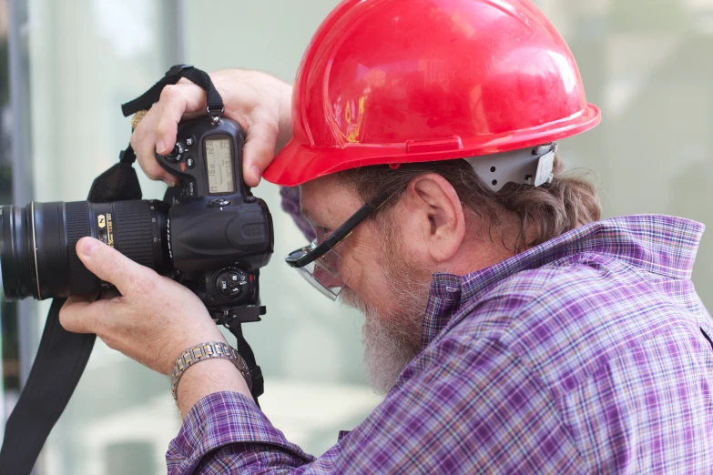 a man with a red helmet holding a camera