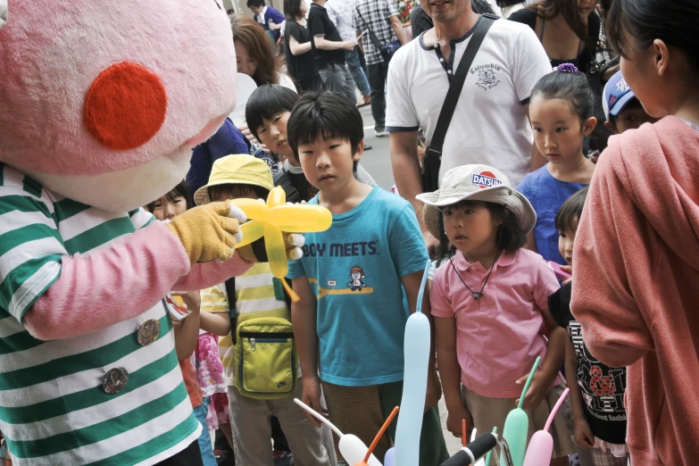 a mascot in a crowd of children in the foreground