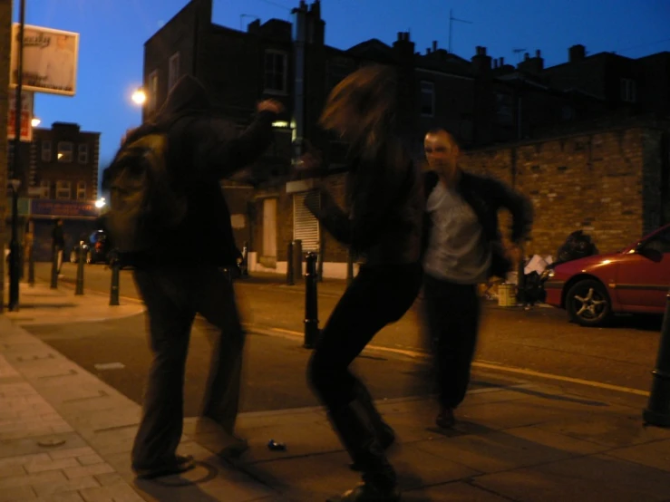 people on the sidewalk skateboarding in the evening