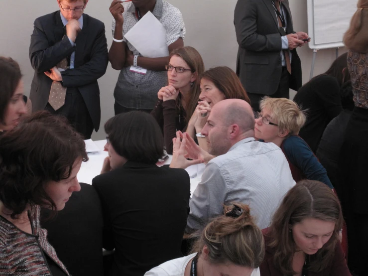 a group of people sitting and talking with each other