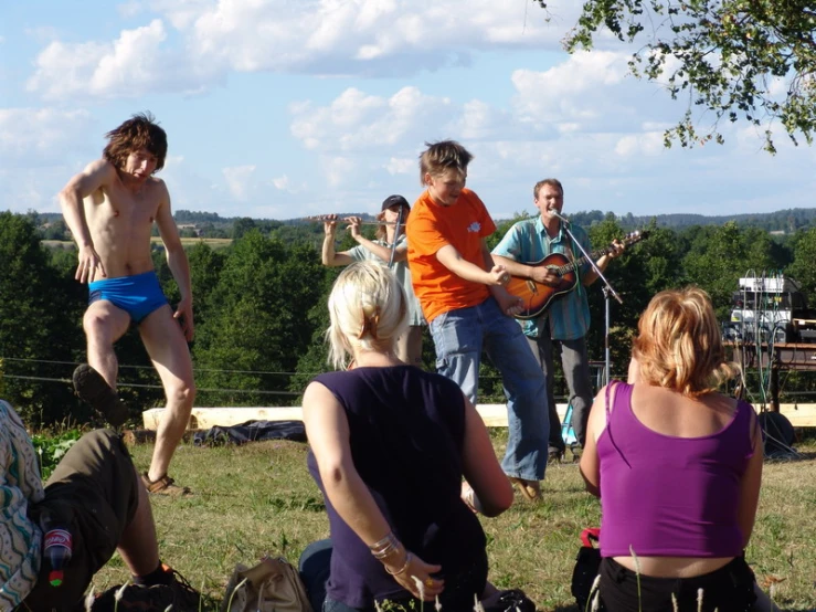 several people dancing on the lawn as others play