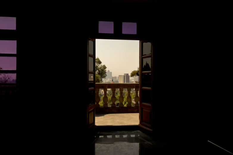 a open door revealing an open landscape and a balcony