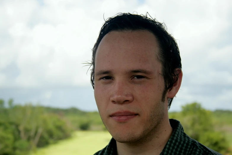 a close up of a person with trees in the background