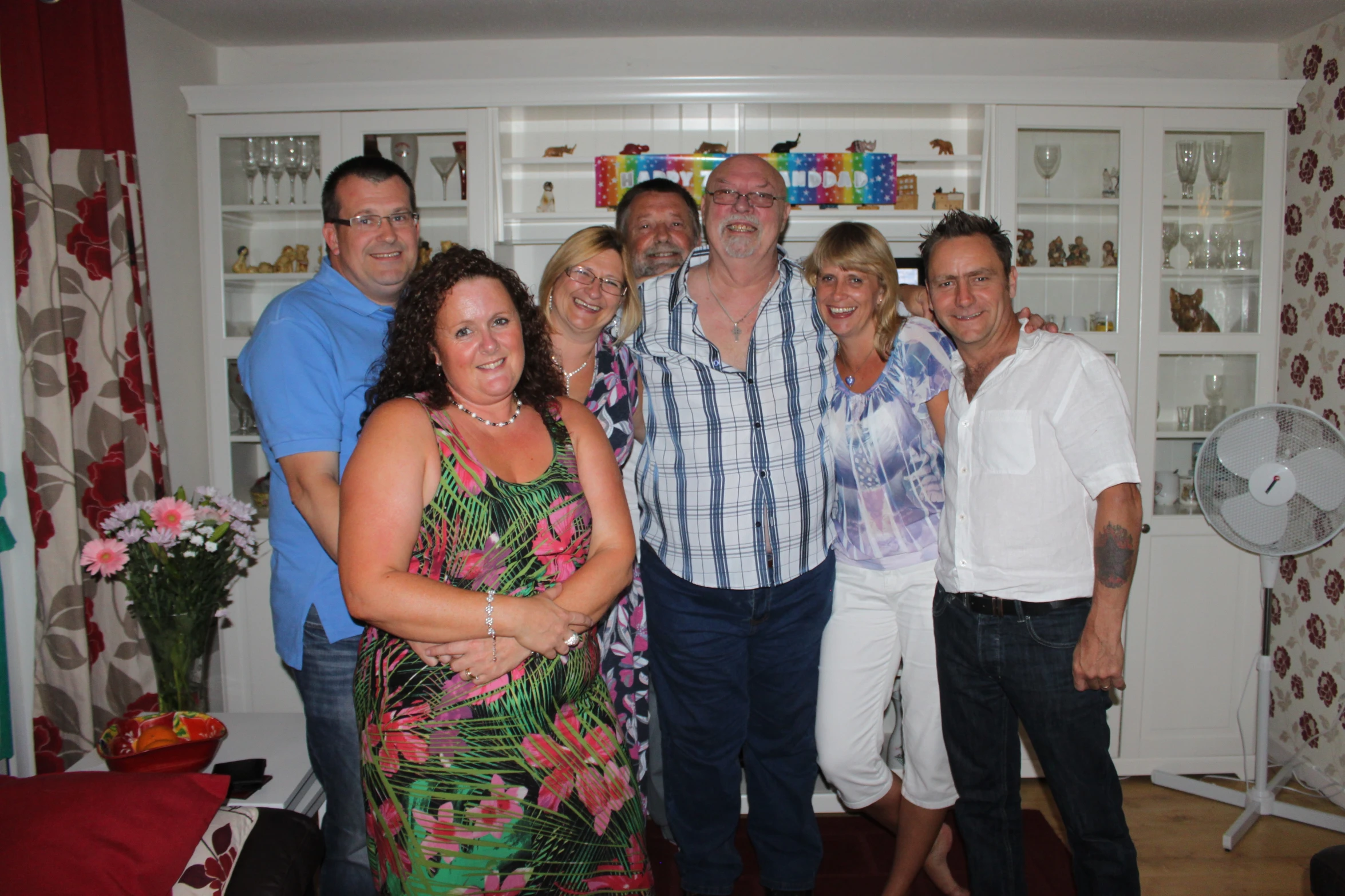 group of people posing for po in front of shelves