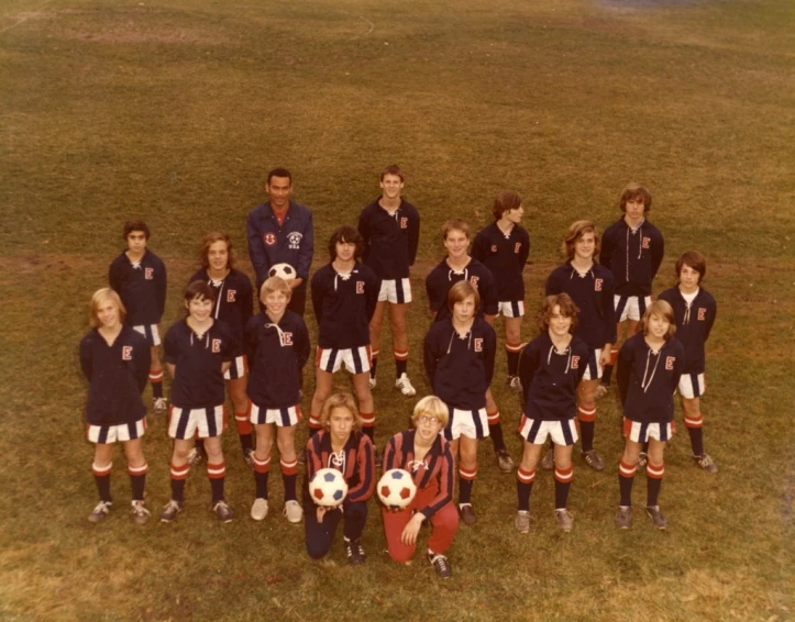 the children are holding soccer balls on the field