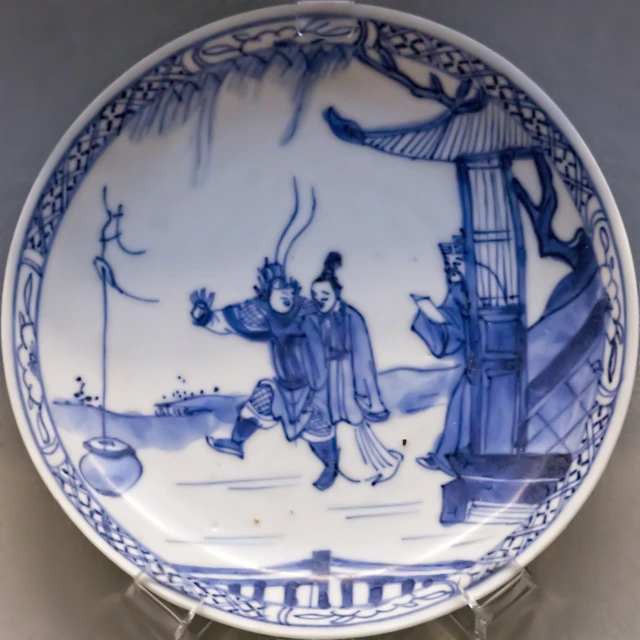 blue and white plate with men playing games in the snow