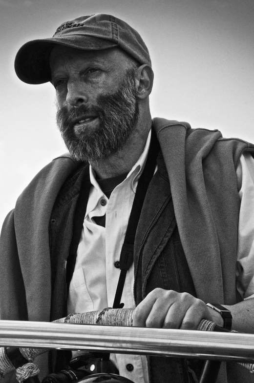 a man in hat and vest holding up a skateboard