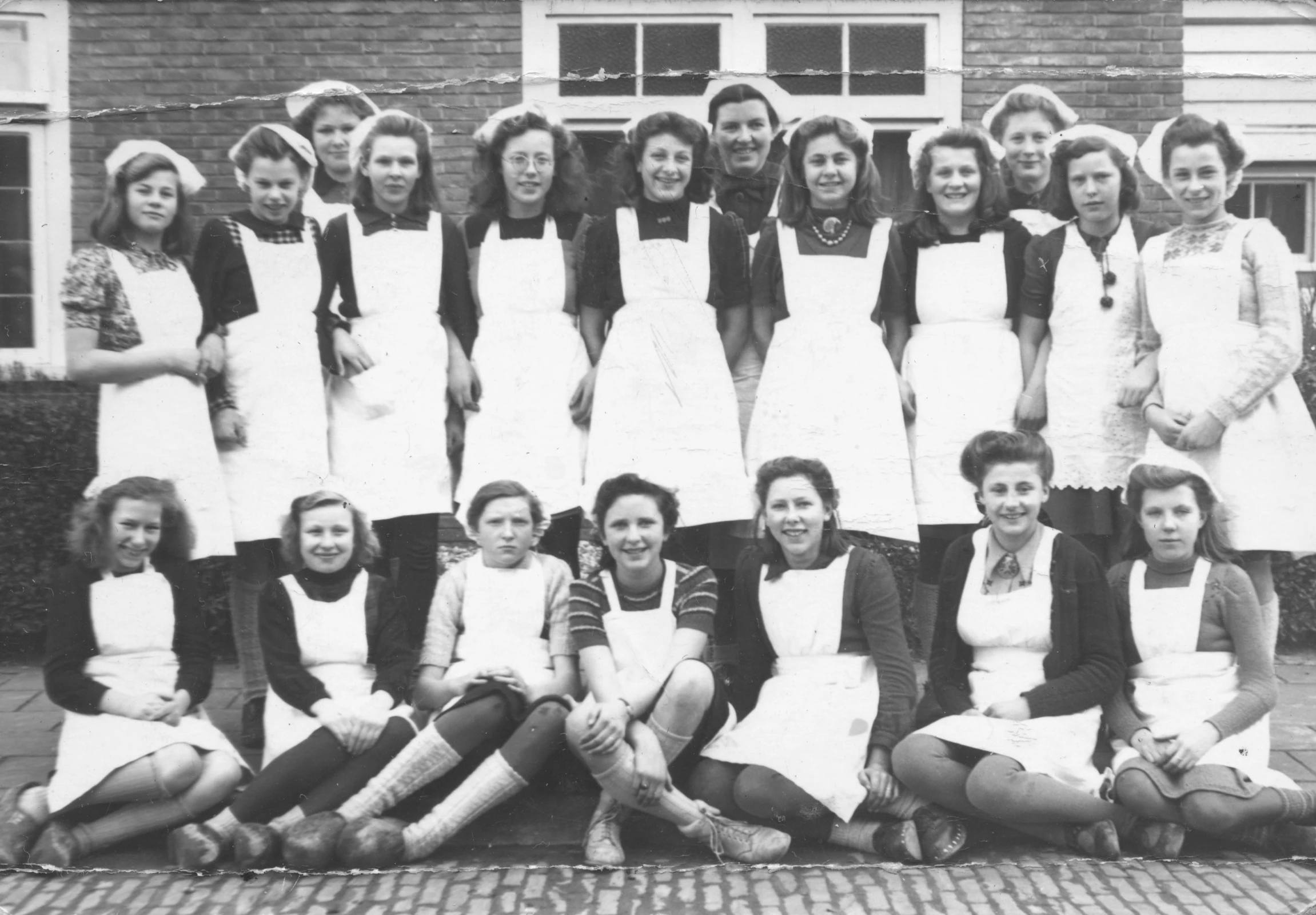 an old pograph of young women in aprons