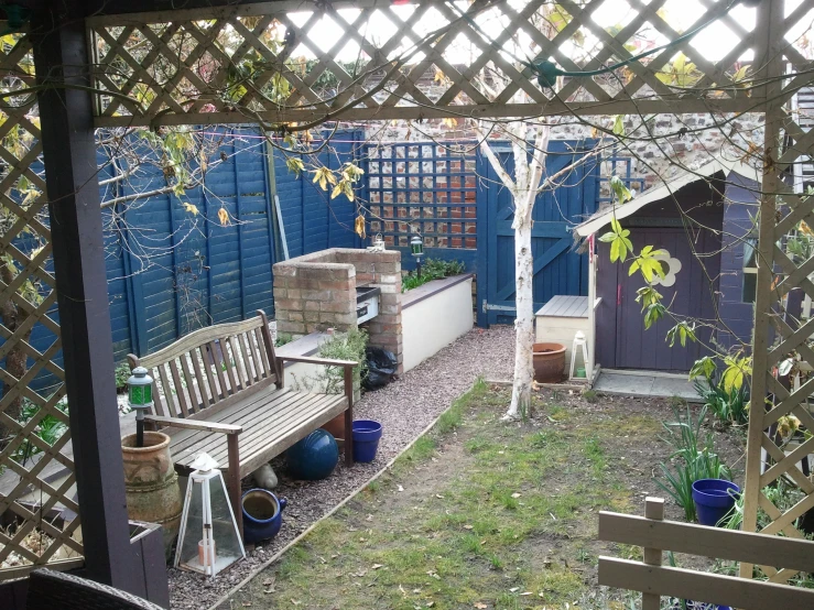 a garden with an outdoor bench and pergolizer