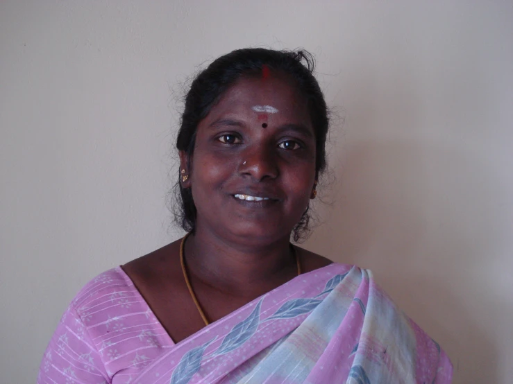 a woman wearing an indian outfit poses for the camera