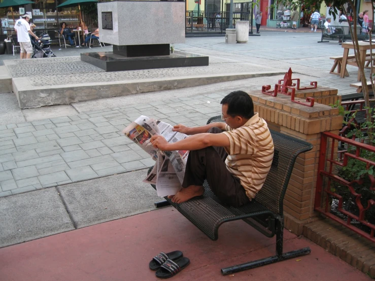 a man reading the news on his bench