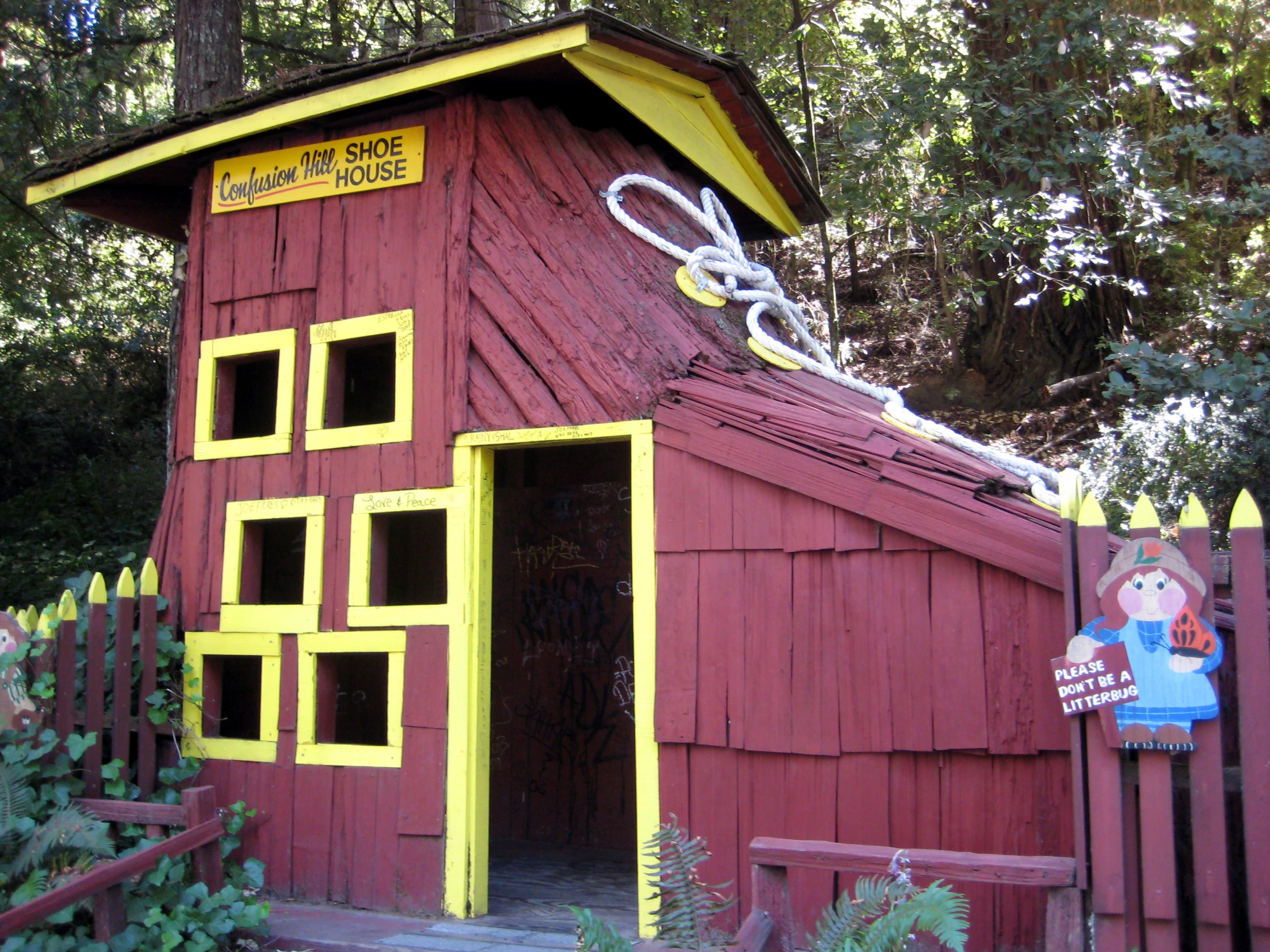 a small red shed that has yellow window frames