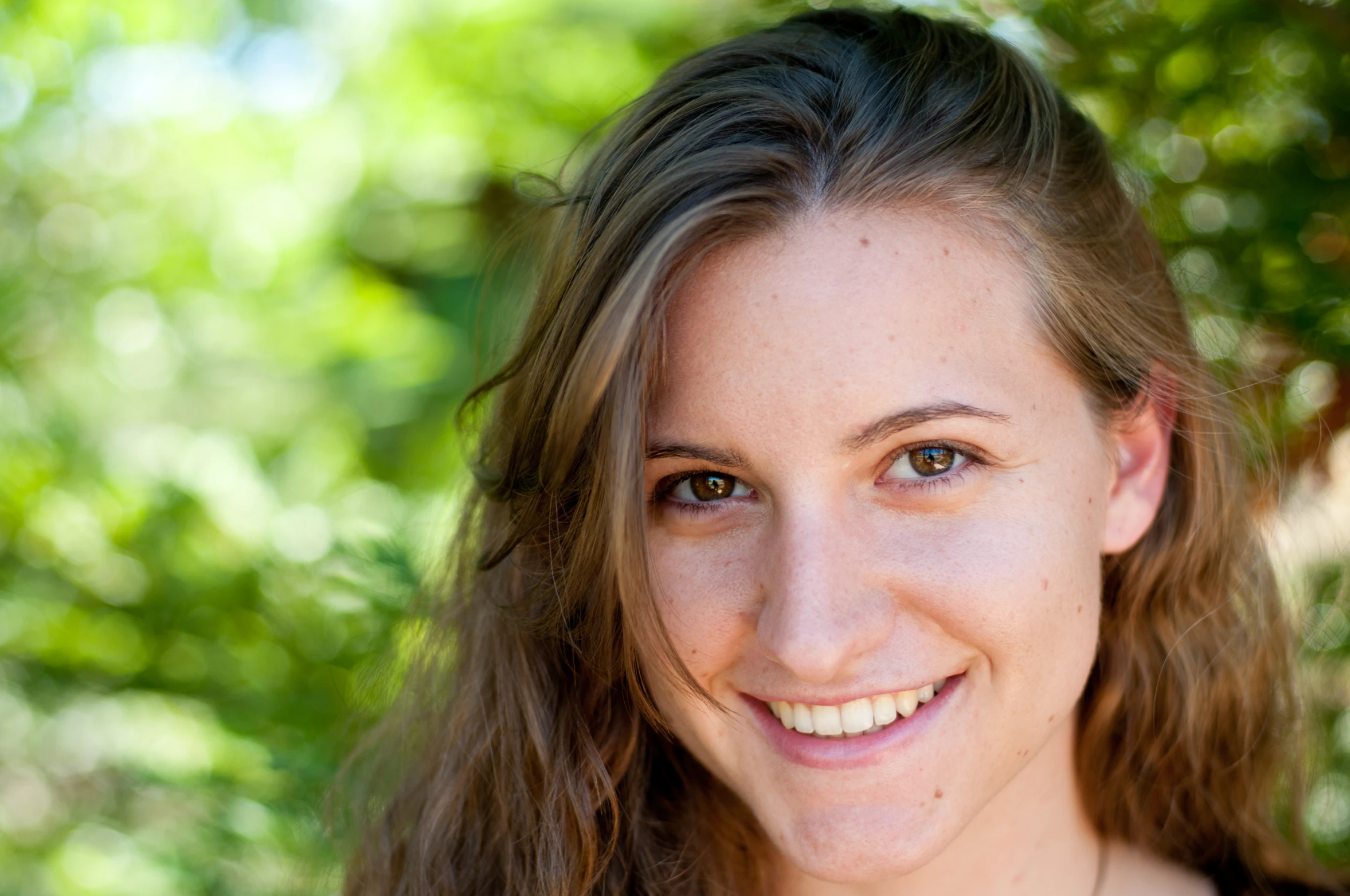 a woman smiles in front of a green background